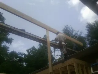 Carpenter setting a ridge beam over a new addition frame — Ice Dam Removal by Roofing Brothers in York Haven