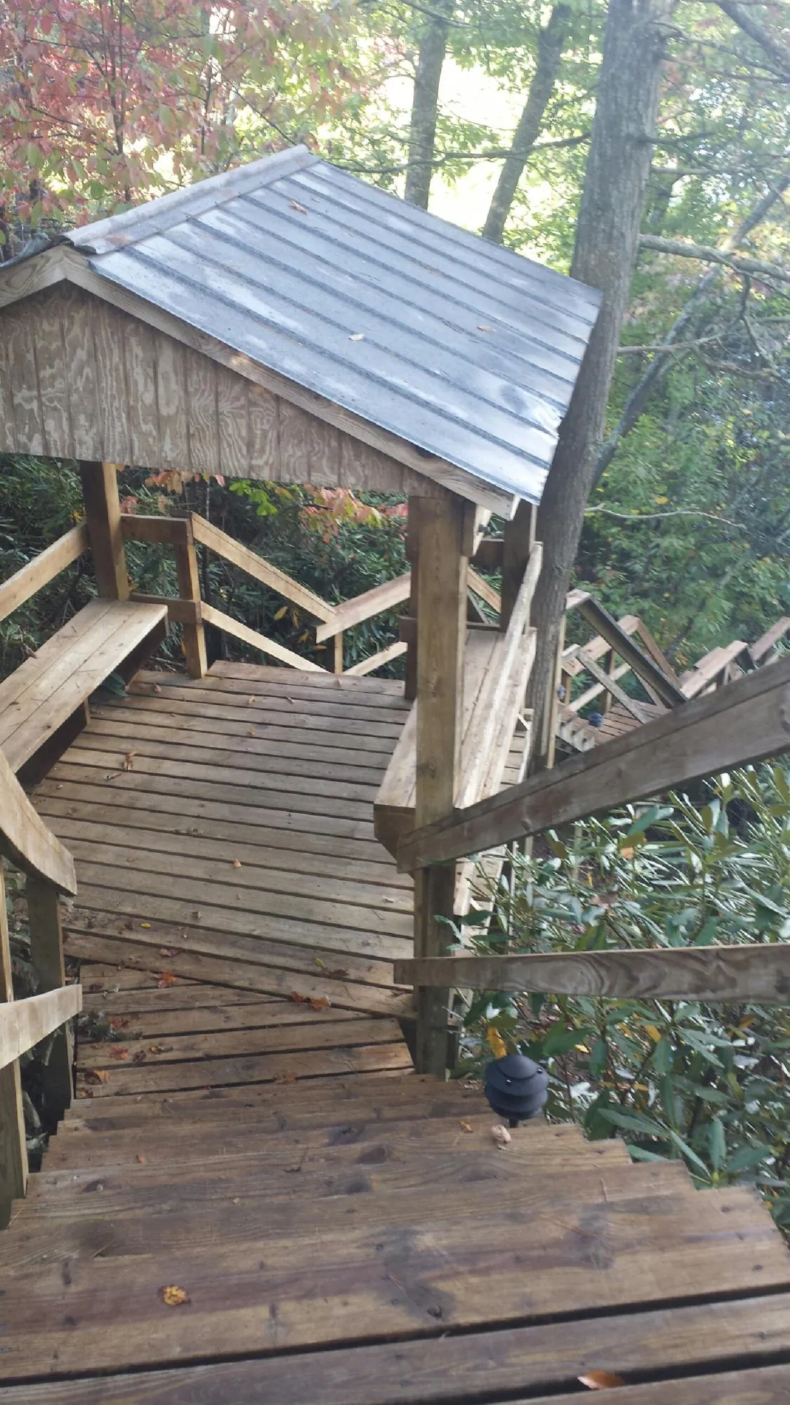 Metal roofed shelter over wooden steps on a wooded walkway — Skylight Repair & Installation work by our crew in York Haven
